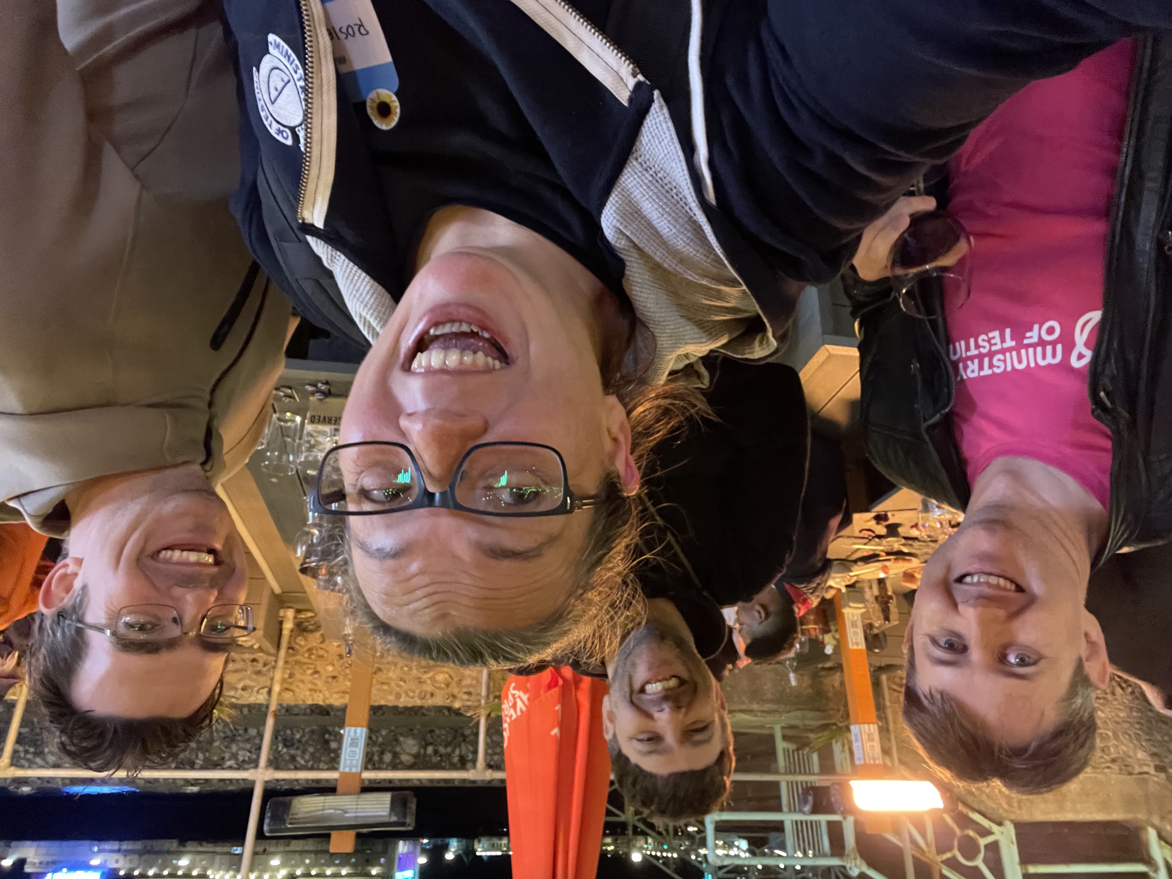 A photo of four attendees from TestBash at OHSO Social venue. They are looking very merry and smiling at the camera. It was getting late. Rosie in particular felt very relieved the end was close.