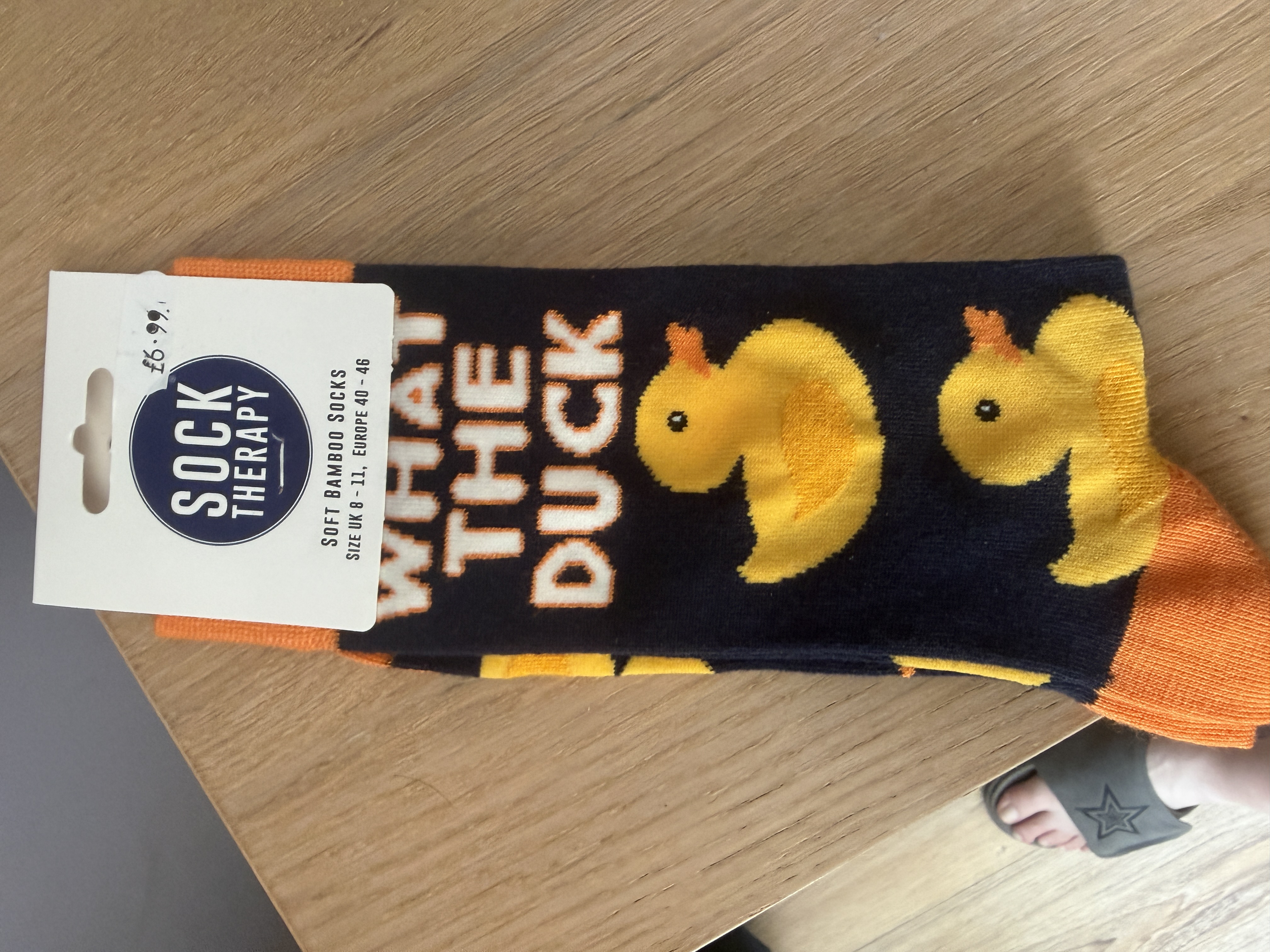 A pair of soft bamboo socks from sock therapy. The base colour is blue with orange at the top and toes. A yellow rubb... image