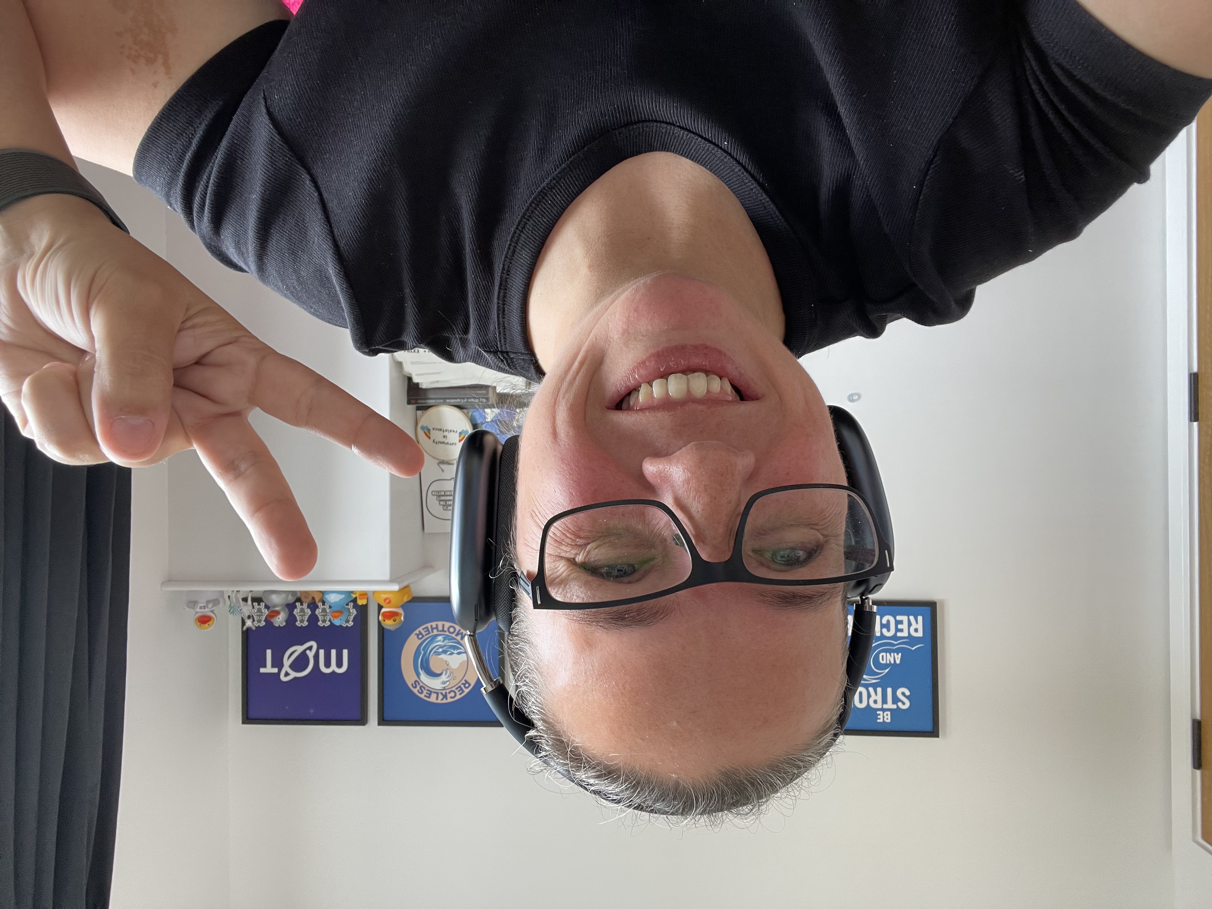Selfie of Rosie, smiling, with a hand victory sign.