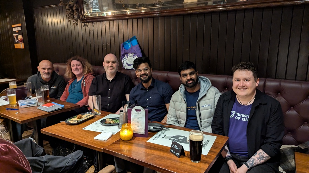 6 people spread in a row in a pub with smiling faces. image