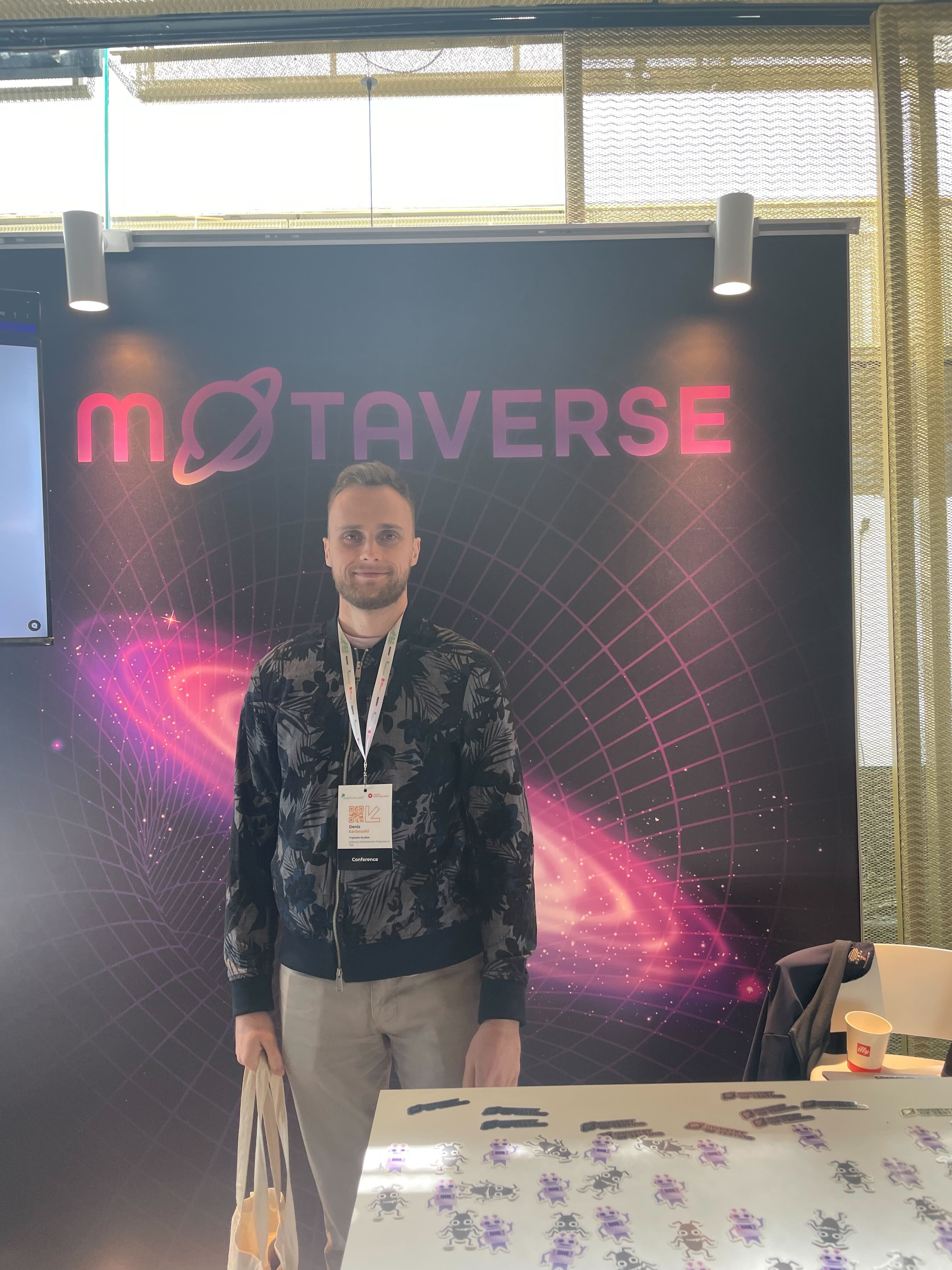 Denis poses infront of a MoTaverse sign.