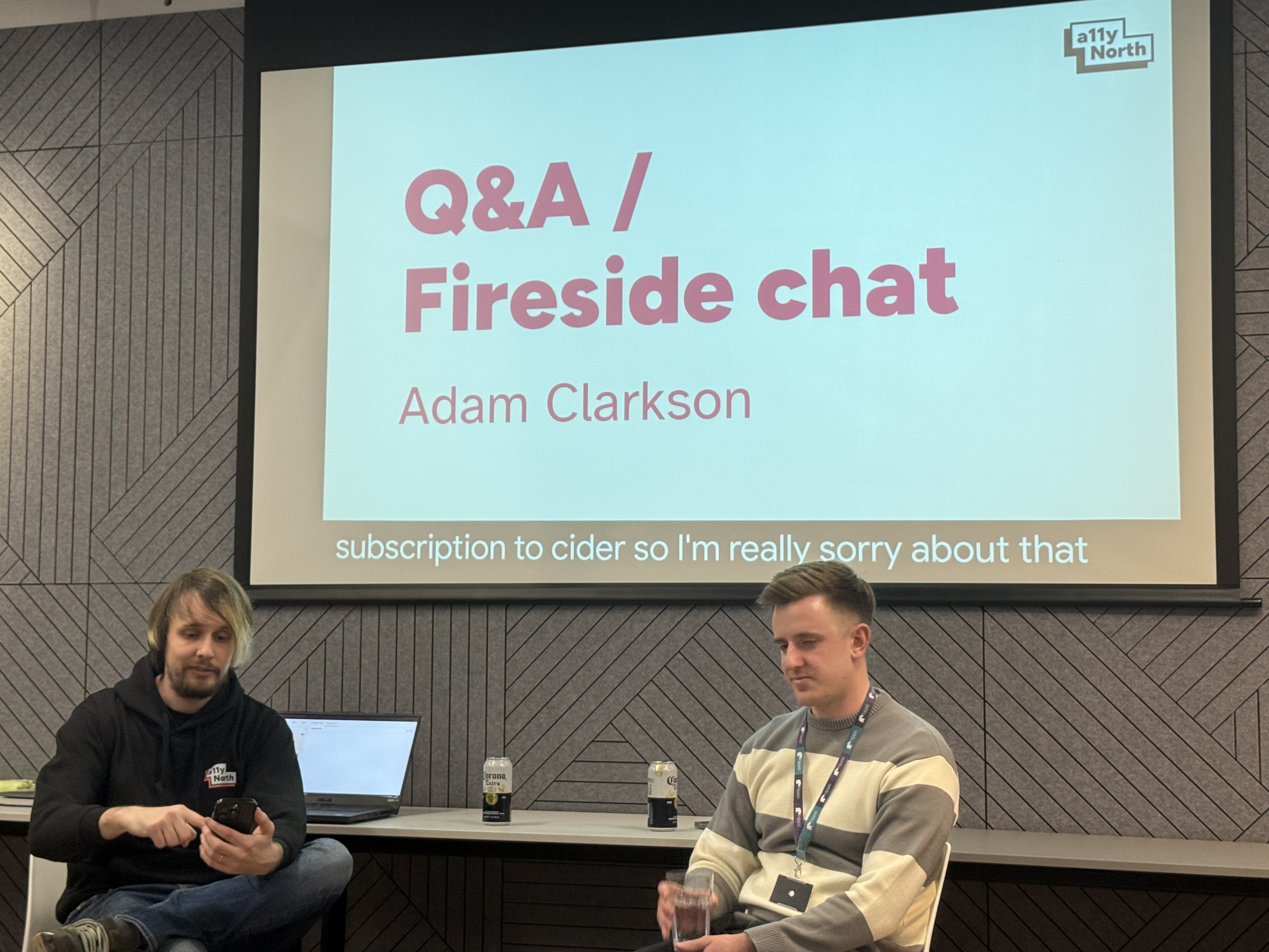 Adam and the host sit at the front with Q&amp;A / fireside chat on the screen behind them  image