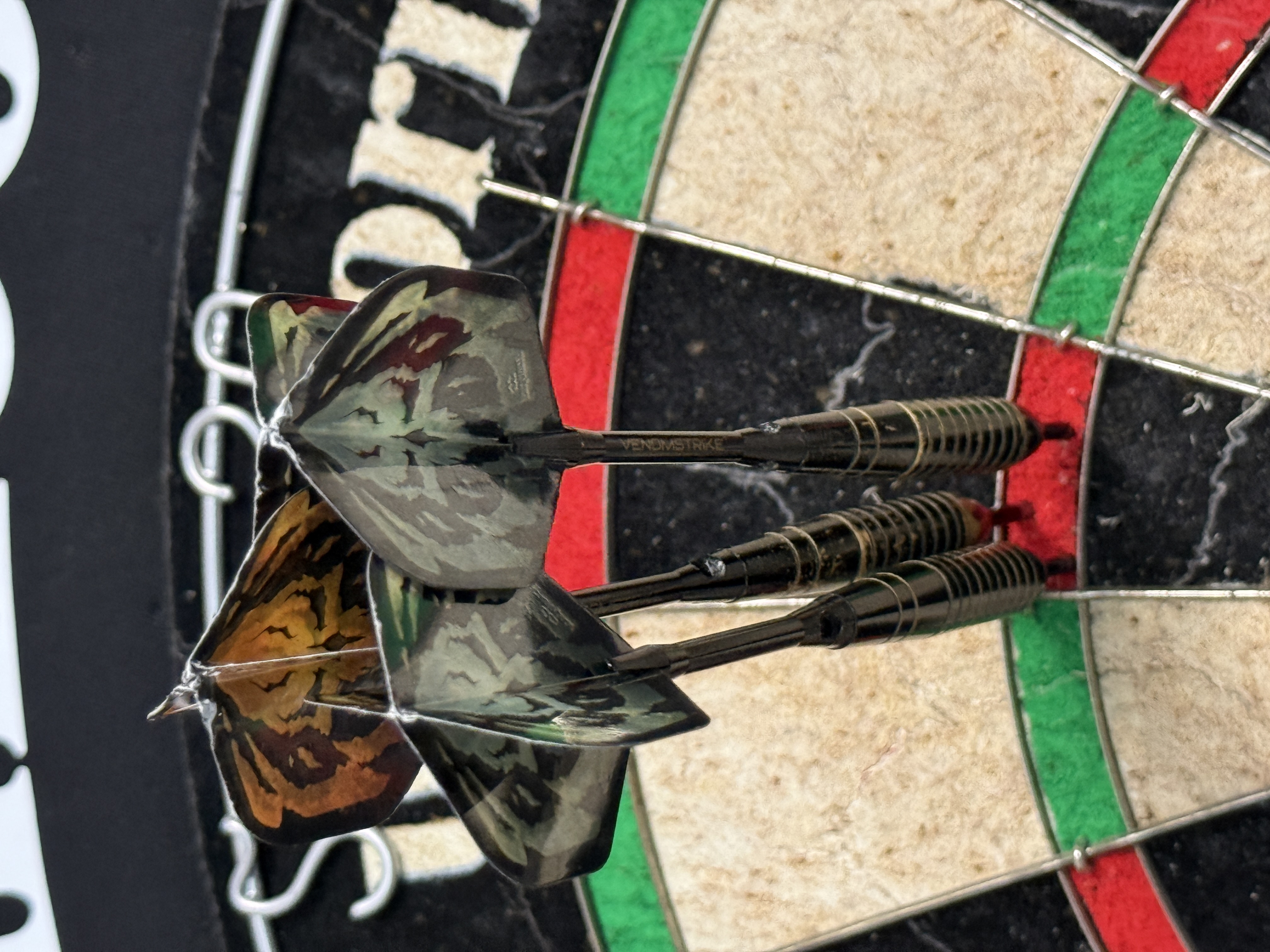 A dart board with all three darts in the treble 20 image
