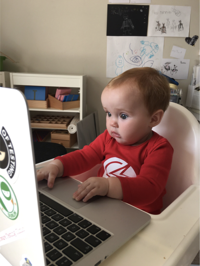 Piper with a laptop on a high chair. image
