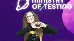 A very smiley testbash 2024 attendee throws up a heart shape joining both of their hands together. This attendee wears a black overall style dress with a yellow and black long sleeved top underneat... image
