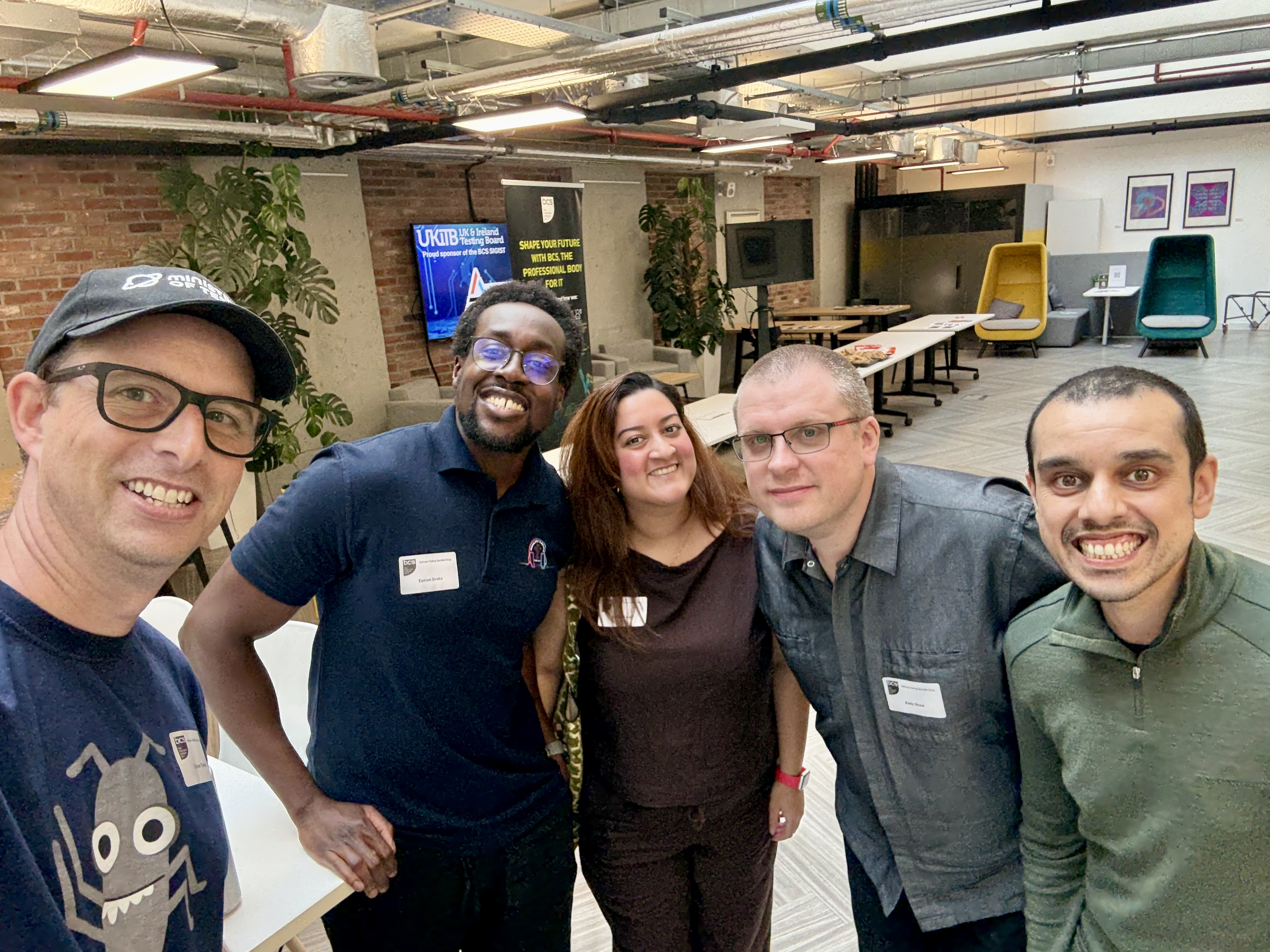 A group of people posing for a selfie in an event space. 