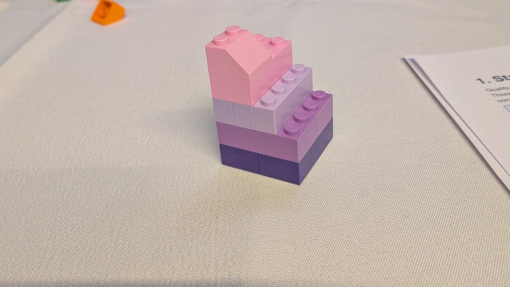 Four layers of lego blocks stacked on top of each other in different shades of purple, going from light to dark from ... image