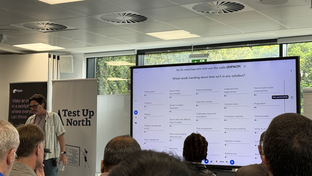Crispin, a white male with a short beard delivering his talk with responses to the question on screen.  image