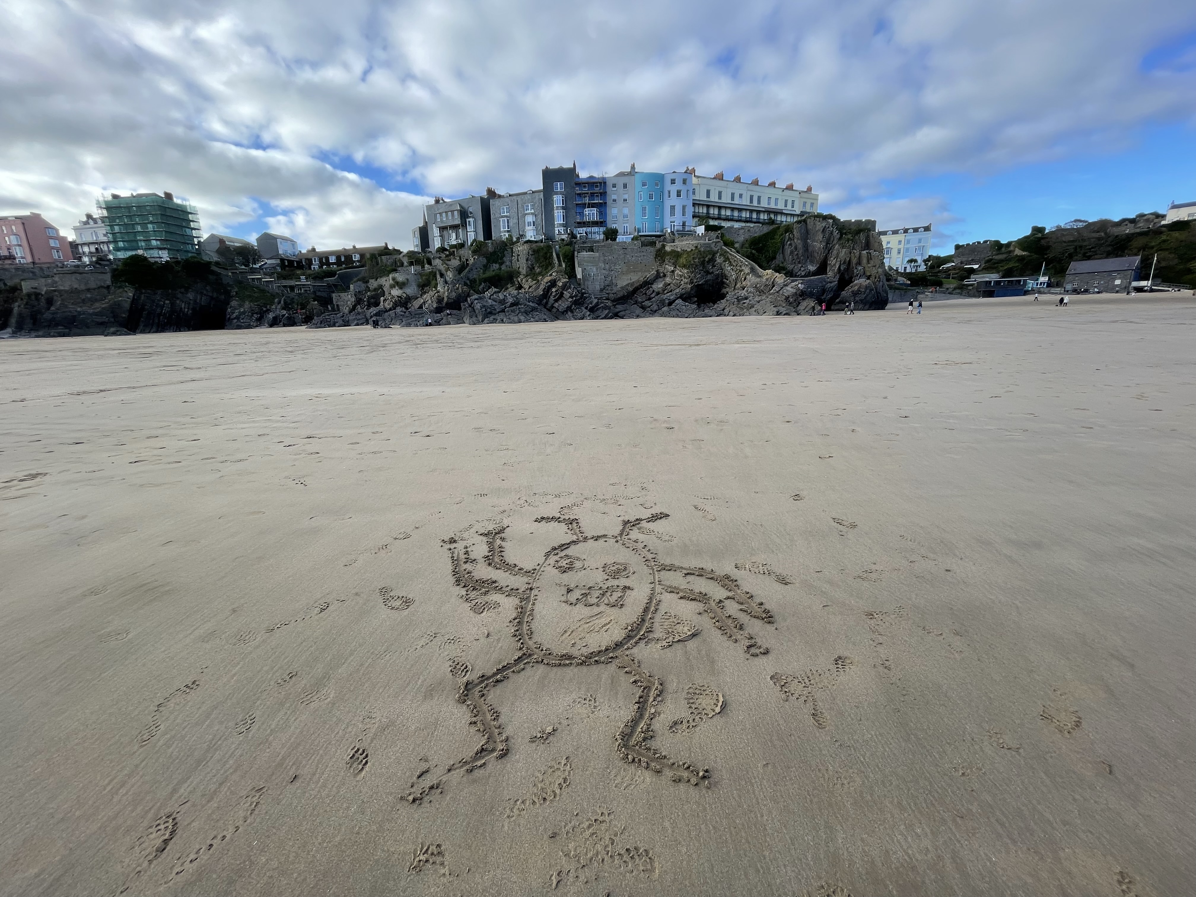 A photo of Bug drawn on the sand at Tenby beach in Wales.