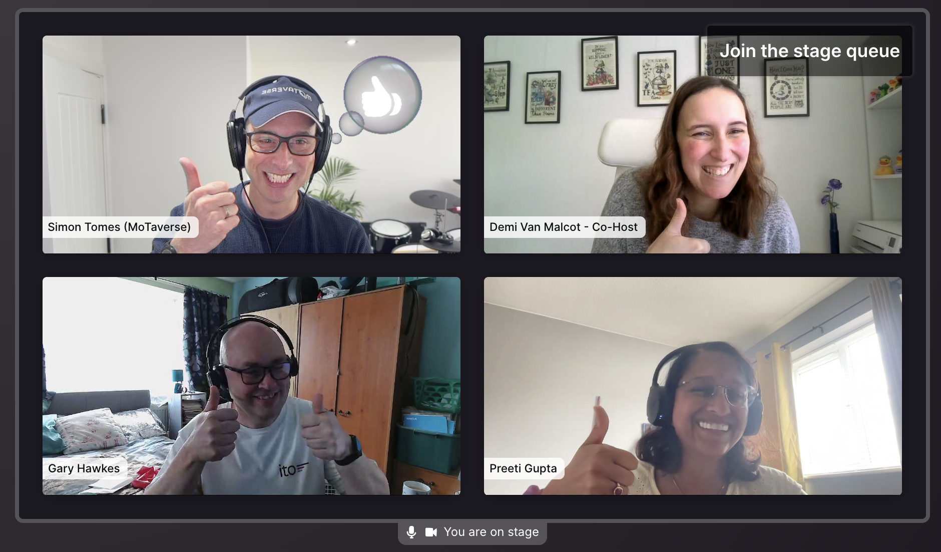 A screenshot of a four-person video call, arranged in a two-by-two grid on a dark interface. All participants are smi... image