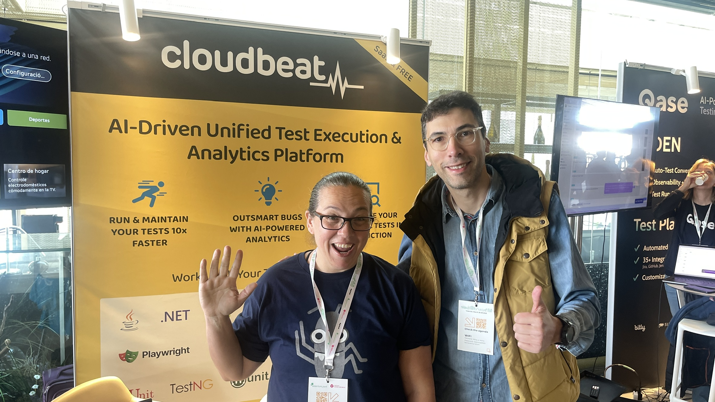 Rosie and another sponsor strike a cheerful pose in front of the Cloudbeat sponsor stand. A bright yellow banner with Cloudbeat branding is behind them.