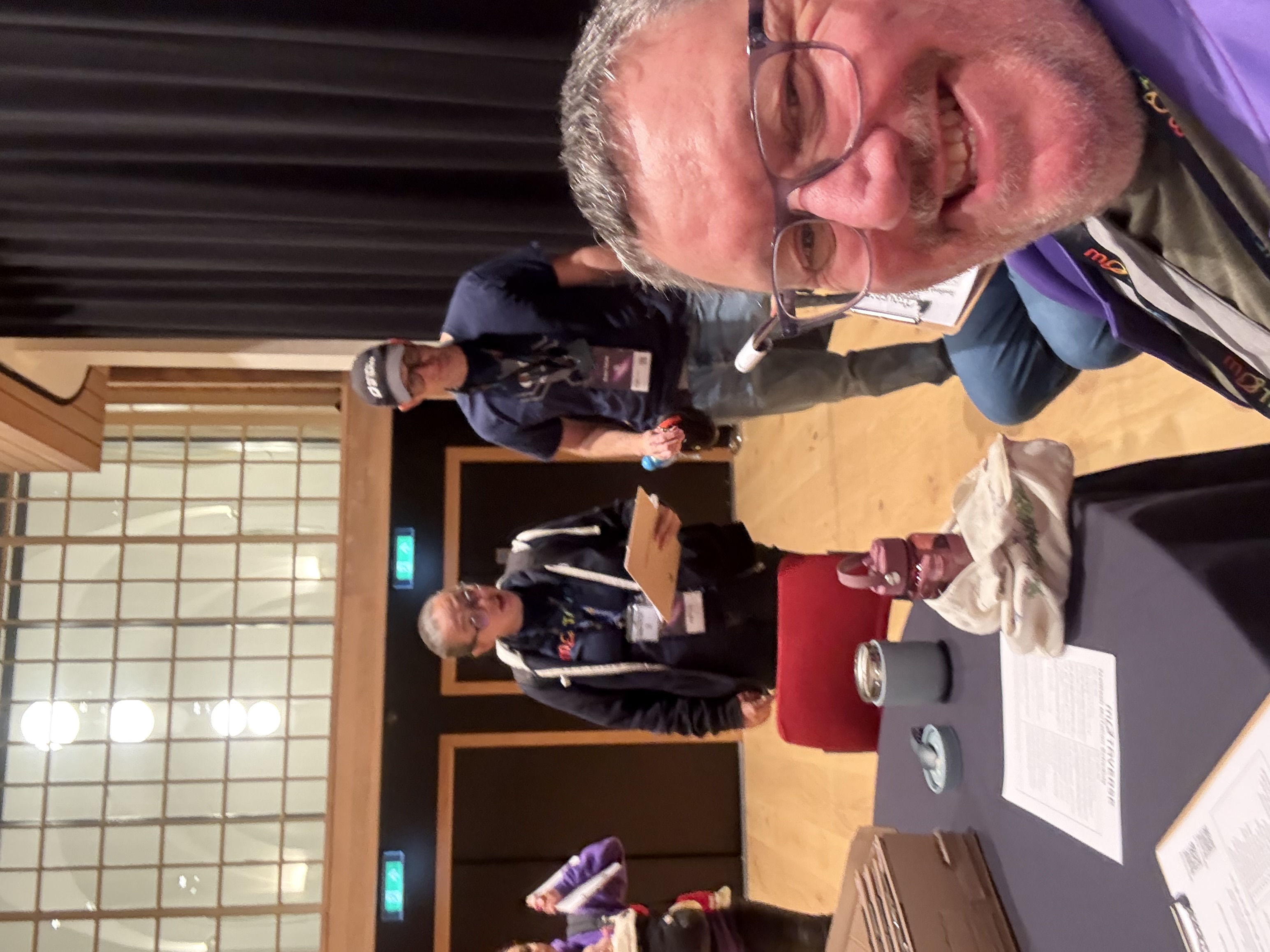 Selfie with Rosie and Simon in the background. All are wearing MoT branded clothes 