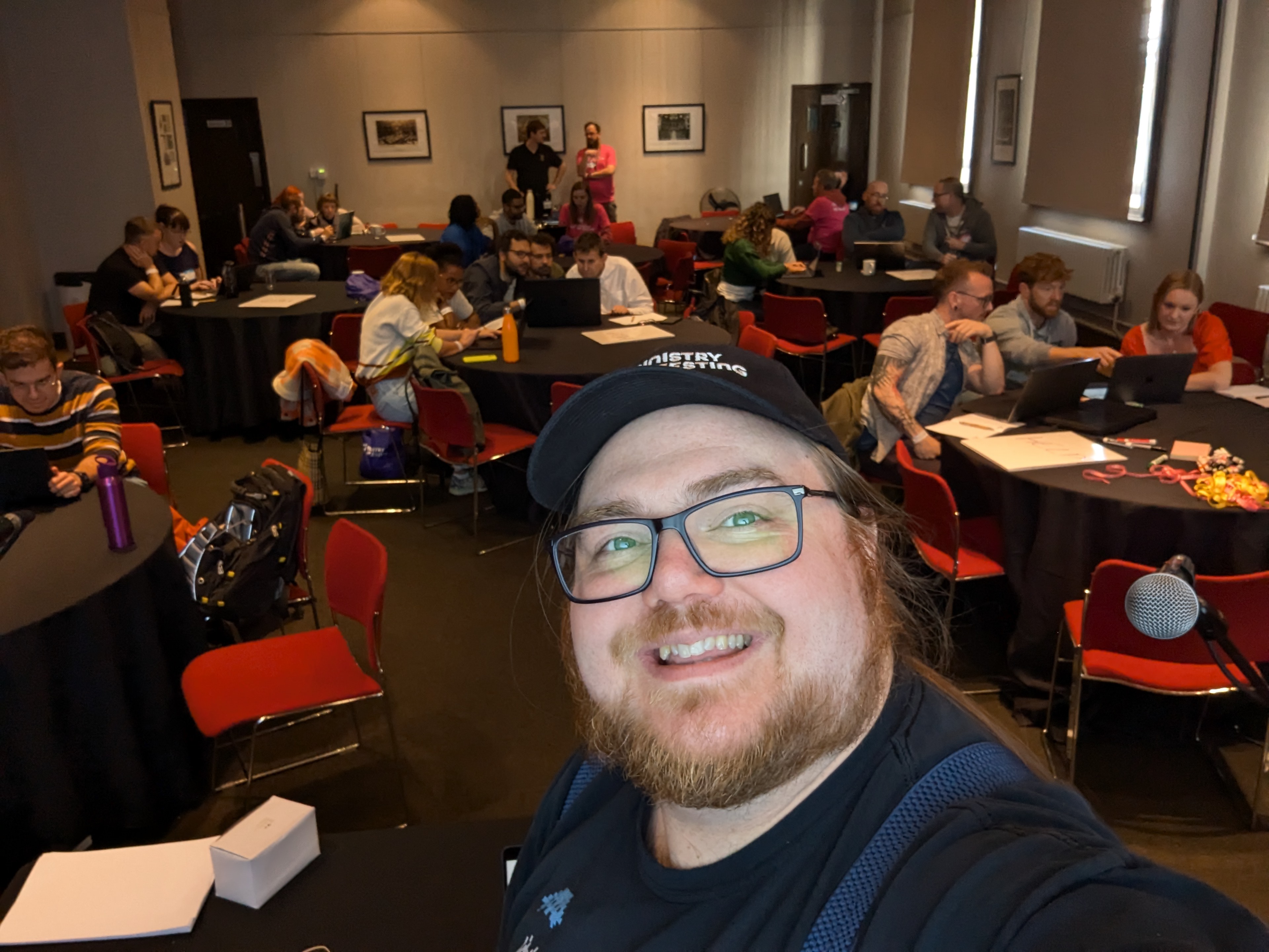 Selfie of Ben Dowen looking back at tables of attendees at the workshop
