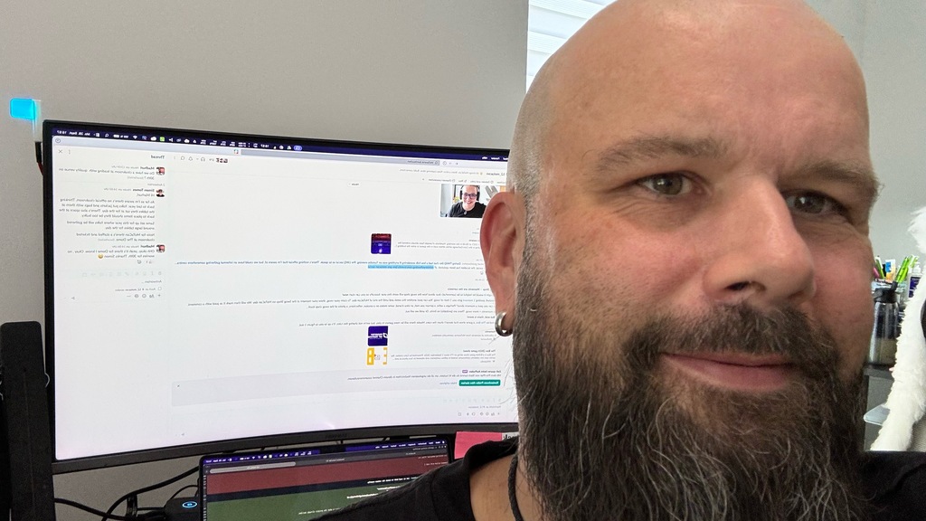 Christian Baumann taking a close-up selfie at his desk while reading Rosie’s Swag Shop announcement in Slack as part ... image