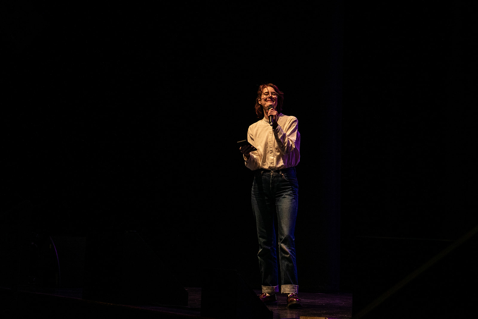 Gwen Diagram stands happy on stage, surrounded by darkness. She looks amazing.