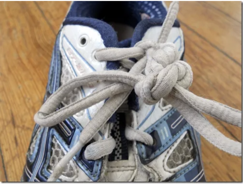 Image shows a trainer/sneaker with lots of knots tied. image