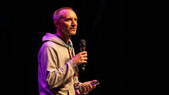 Simon Rigler on stage doing a 99 second talk. image