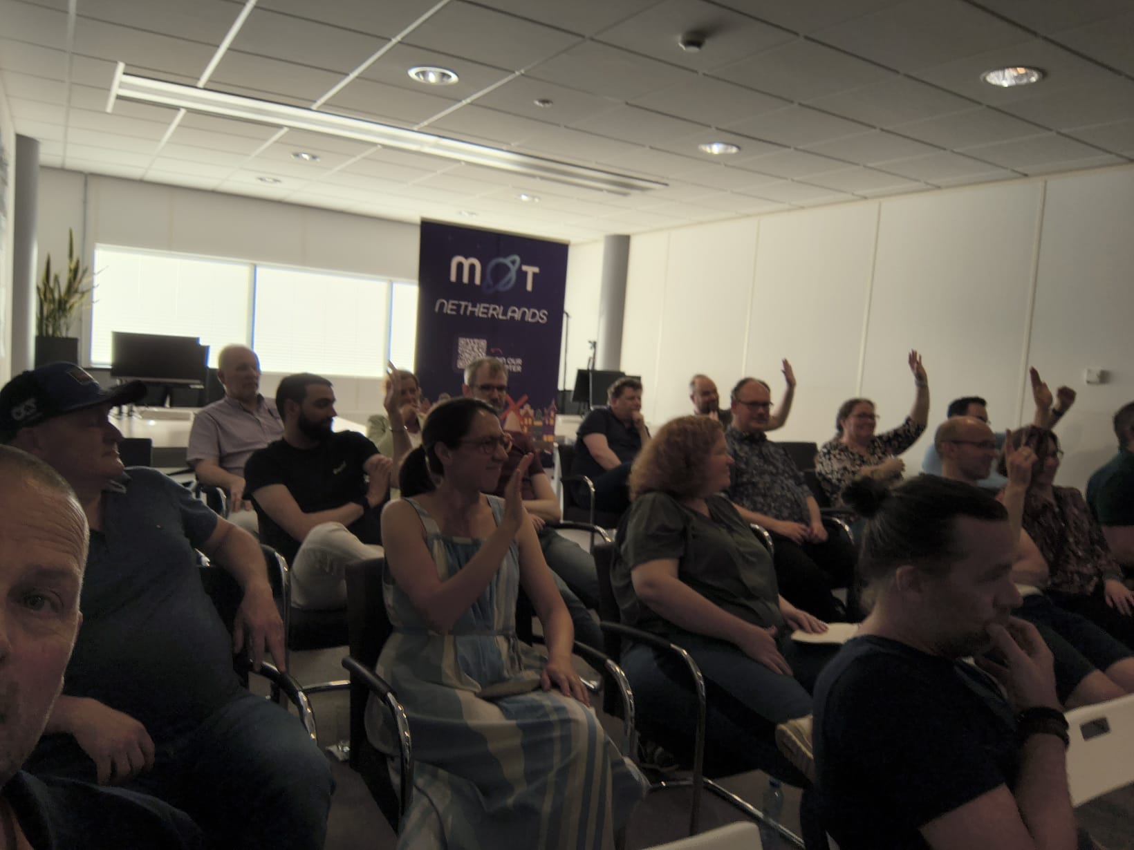 Attendees raising their hand at the MoT-NL Chapter Meeting for a question by Veerle image