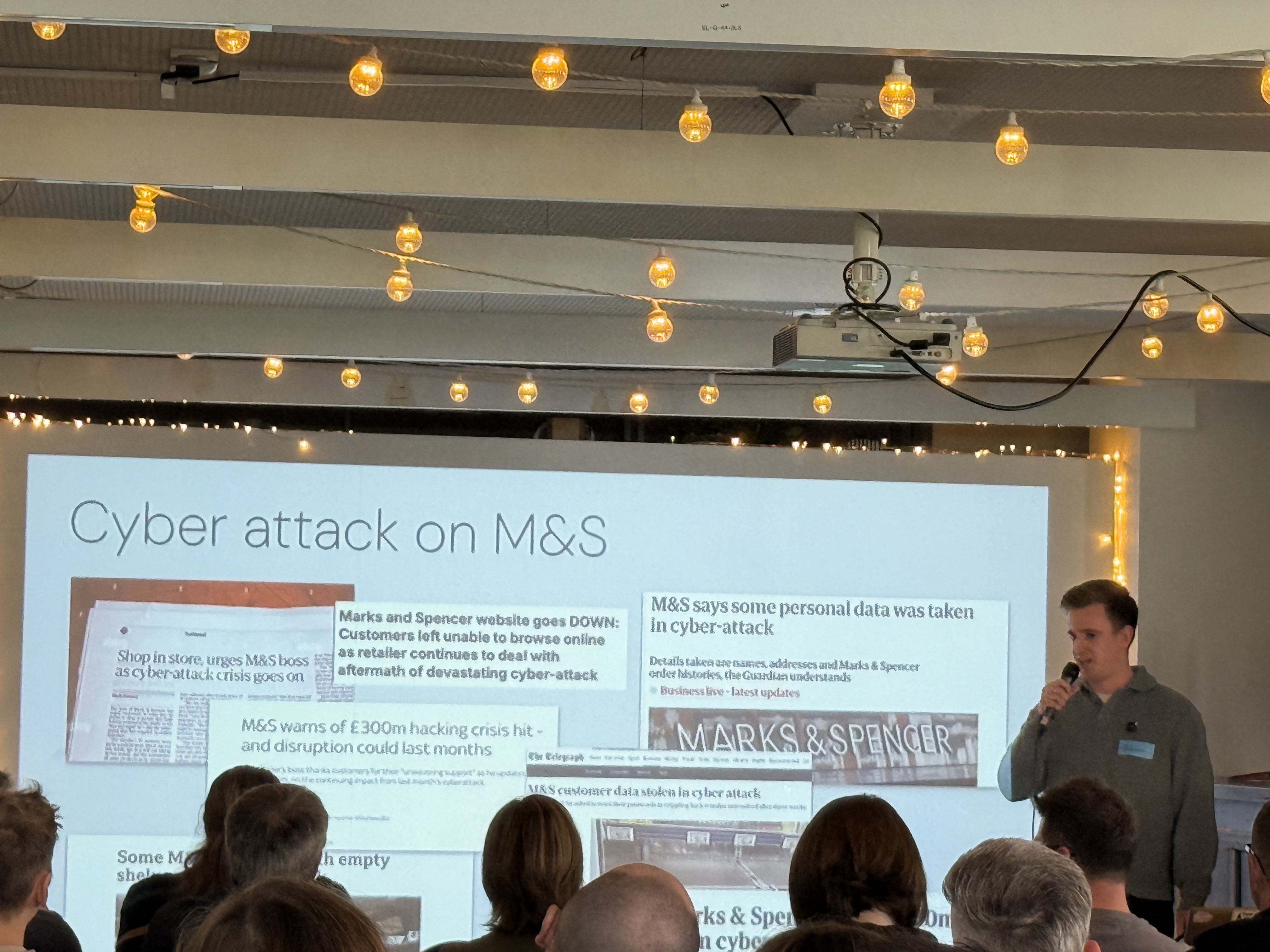 Adam in front of a slide with clips from articles about the M&amp;S cyber attack  image
