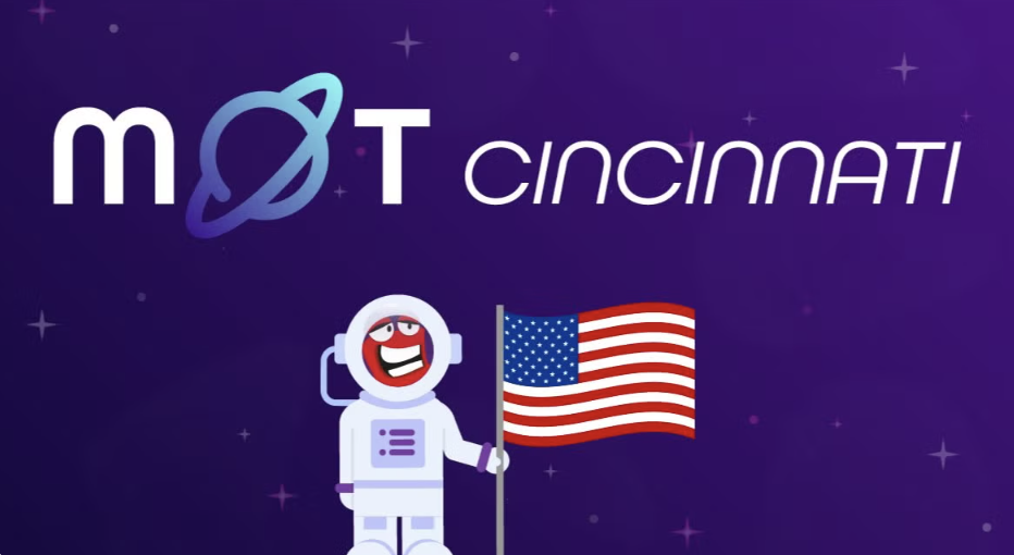 Graphic for Ministry of Testing Cincinnati meetup. The word ‘MoT’ is written in white with a blue planet forming the letter ‘o,’ followed by the word ‘Cincinnati’ in sleek white text. At the bottom, a smiling cartoon astronaut stands holding an American flag against a purple starry background.