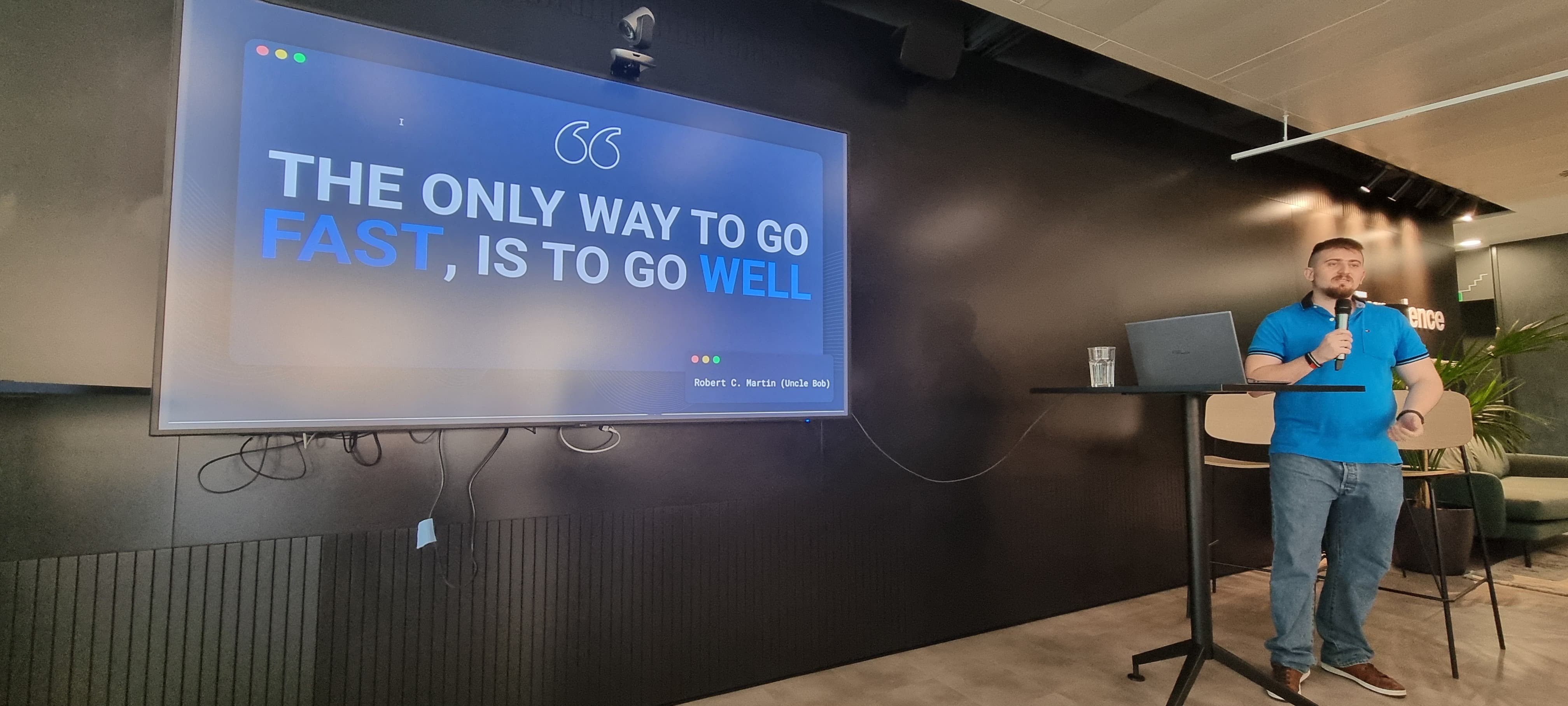 Mauro presenting a slide that reads "The only way to go fast, is to go well"